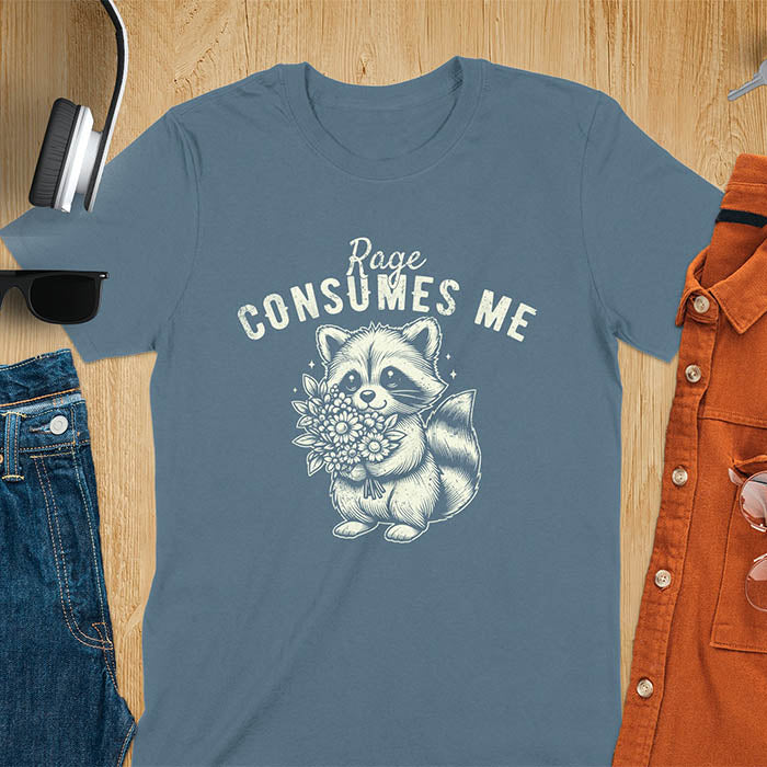 A t-shirt featuring a raccoon holding a bouquet of flowers. Text: Rage CONSUMES ME in a bold, arched font. This dark humor tee is a mental health meme and raccoon meme design. A weirdcore funny and weird funny shirt for a funny gag gift. A raccoon cuteness design, this is one of those shirts that go hard, a unisex and comfortable trendy tee. An animal person gift or girlfriend friend gift, a mom gift alternative.