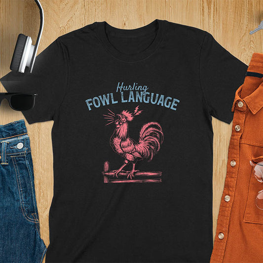 Vintage t-shirt with line art drawing of a chicken rooster standing on a fence in a farm crowing with exaggerated open beak. The design gives a fun and quirky vibe. Text says hurling fowl language.