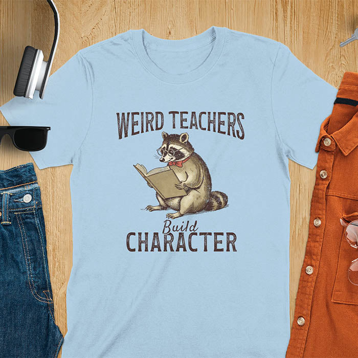 Weird Teachers Build Character shirt featuring a raccoon reading a book with glasses and a red bow tie. Vintage distressed font and brownish monotone give it a retro look. Perfect back-to-school shirt, funny teacher gift, or teacher appreciation tee.