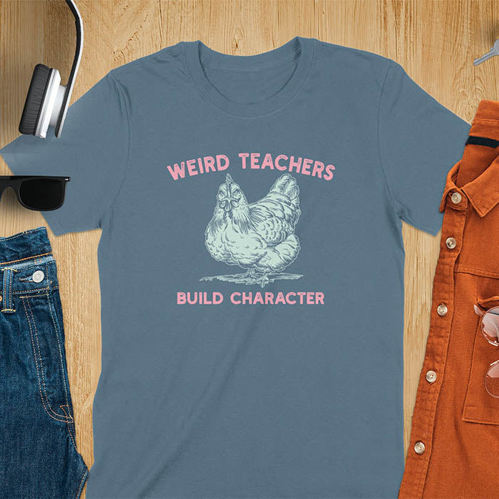 This teacher t-shirt features a grumpy-faced hen. The vintage font with distressed effect says Weird Teachers above the hen and Build Character below, all in a vintage color palette.