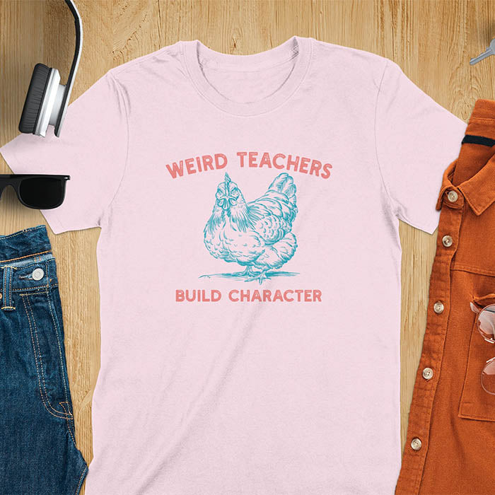 This teacher t-shirt features a grumpy-faced hen. The vintage font with distressed effect says Weird Teachers above the hen and Build Character below, all in a vintage color palette.