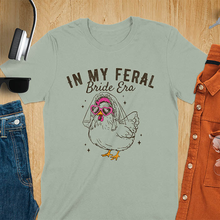 A chicken wearing sunglasses and a bride's veil, with the text "In My Feral Bride Era".