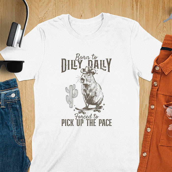 Capybara in a cowboy hat on a skateboard western style. Born to Dilly Dally and Forced to Pick Up the Pace text. Distressed style.