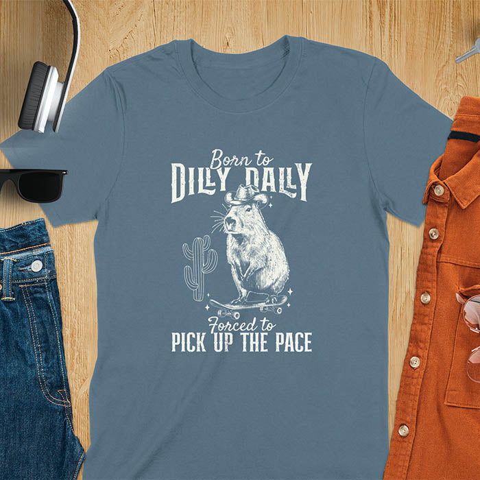 Capybara in a cowboy hat on a skateboard western style. Born to Dilly Dally and Forced to Pick Up the Pace text. Distressed style.