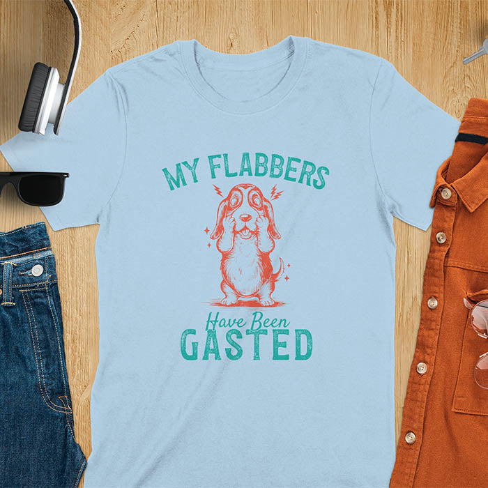 A t-shirt with a startled basset hound puppy. Its characteristic drooping ears are shown, and small lightning bolts radiate from its head. Text: "MY FLABBERS Have Been GASTED". This cute dog tee-shirt displays dog cuteness & cuteness puppy. A funny dog shirt & dog lover gift for dog person, dog mom, dog dad, dog owner. A retro dog shirt & vintage dog tee, animal person gift, gift for mom, hers.