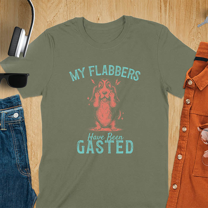 A t-shirt with a startled basset hound puppy. Its characteristic drooping ears are shown, and small lightning bolts radiate from its head. Text: "MY FLABBERS Have Been GASTED". This cute dog tee-shirt displays dog cuteness & cuteness puppy. A funny dog shirt & dog lover gift for dog person, dog mom, dog dad, dog owner. A retro dog shirt & vintage dog tee, animal person gift, gift for mom, hers.