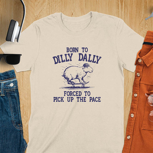 A capybara skateboarding, donning a protective helmet .Above it, the words "Born to dilly dally", while below, "Forced to pick up the pace". Rendered in a charming vintage font with a faded look.