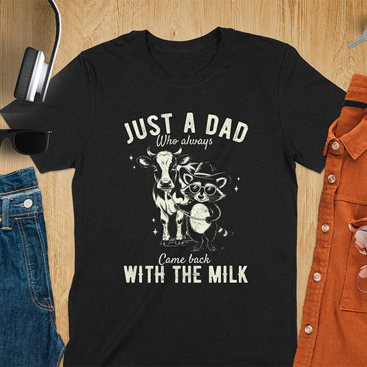 A t-shirt with a raccoon wearing a cowboy hat and sunglasses, holding a leash to a cow. Text: Just a Dad WHO ALWAYS above and Came Back WITH THE MILK below. This funny raccoon shirt features funny graphics, a dad t shirt for a funny fathers day or fathers day gift. A funny shirt for dad or gift for dad, a husband gift or father in law gifts. Could be used for a dad announcement, expectant dad, or godfather proposal.