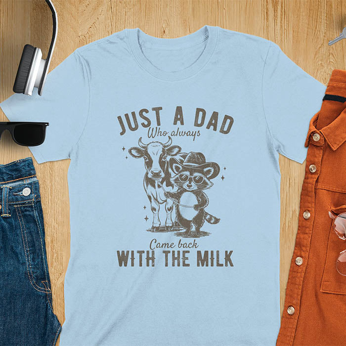 A t-shirt with a raccoon wearing a cowboy hat and sunglasses, holding a leash to a cow. Text: Just a Dad WHO ALWAYS above and Came Back WITH THE MILK below. This funny raccoon shirt features funny graphics, a dad t shirt for a funny fathers day or fathers day gift. A funny shirt for dad or gift for dad, a husband gift or father in law gifts. Could be used for a dad announcement, expectant dad, or godfather proposal.