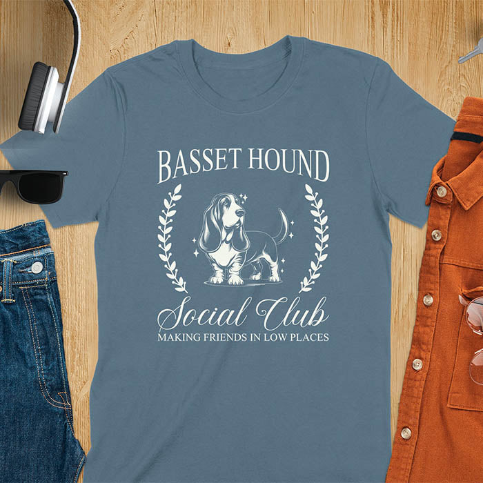 A t-shirt featuring a vintage-style basset hound design. Includes Basset Hound, Social Club, Short & Sweet Forever text, laurel wreaths, EST 2024, and a centered dog illustration for a timeless, elegant look.