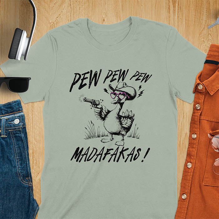 A t-shirt with a goose wearing a cowboy hat and sunglasses, holding a pistol. Text: "PEW PEW PEW" above and "MADAFAKAS!" below. This funny meme shirt features a silly funny goose with a sarcastic quote. A funny genz meme and sarcastic meme shirt, a snarky humorous funny adult joke. An animal person gift or goose lovers gift, a sassy quote funny funny fuck gift. A mom Gift alternative.