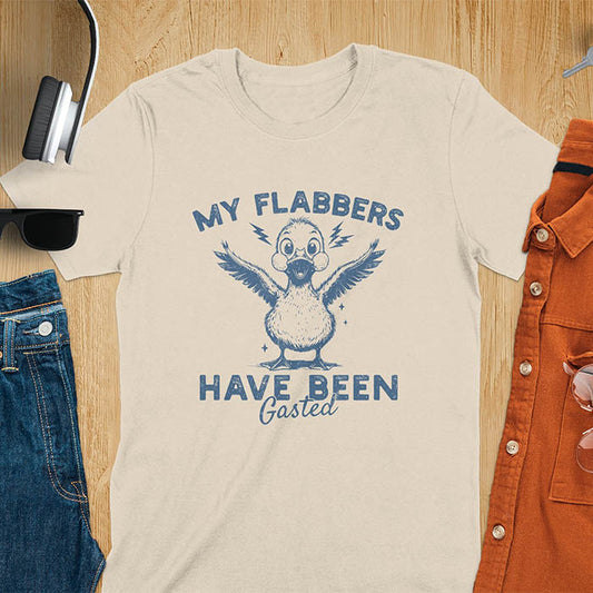 A t-shirt with a startled goose flapping its wings. Text: "MY FLABBERS" above and "HAVE BEEN GASTED" below. This Sarcastic tee-shirt features Kawaiiness cuteness and goose cuteness, a GenZ meme tee. A Funny gag gift and Anxiety t-shirt, a silly funny goose. A funny goose shirt tapping into Weirdcore memes and weirdcore t shirt aesthetics. An animal person gift or goose lover gifts, a Mom gift alternative.