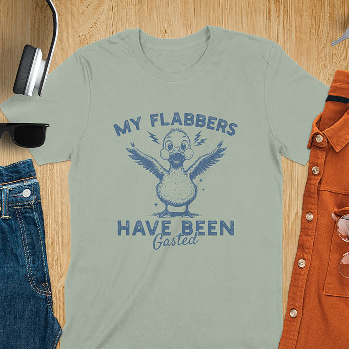 A t-shirt with a startled goose flapping its wings. Text: "MY FLABBERS" above and "HAVE BEEN GASTED" below. This Sarcastic tee-shirt features Kawaiiness cuteness and goose cuteness, a GenZ meme tee. A Funny gag gift and Anxiety t-shirt, a silly funny goose. A funny goose shirt tapping into Weirdcore memes and weirdcore t shirt aesthetics. An animal person gift or goose lover gifts, a Mom gift alternative.