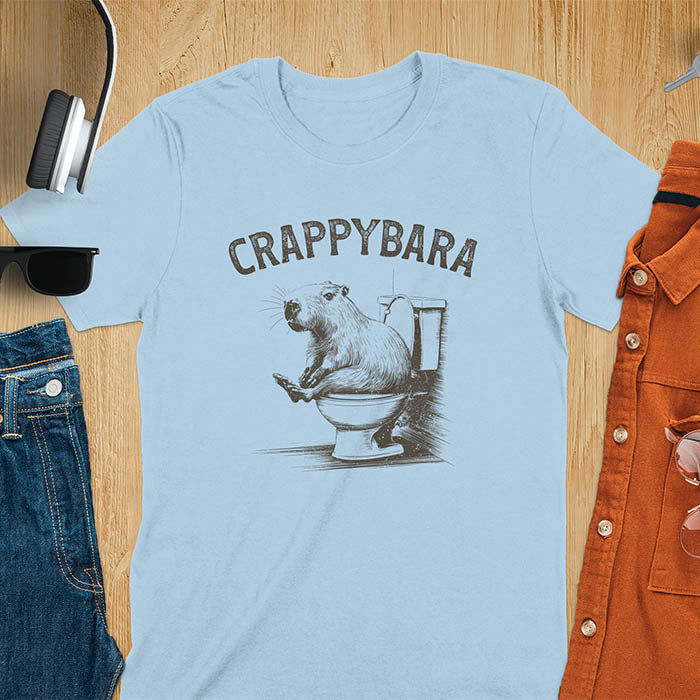 A t-shirt with a capybara on a toilet. Text: "CRAPPYBARA". This Crappybara Tshirt is an inappropriate shirt, offensive shirt & Toilet Humor Gag Gift. A Funny Meme Tee-shirt, Trending meme shirt, genz gen z weirdcore t-shirt. Features Kawaiiness Kawaiiful, Capybara cuteness, Weird capybara gift, Funny Vintage Capybara Shirt. For animal person gift, pet lovers tee, Animal Lover T-shirt, gift mom hers. A Y2K tee-shirt, Vintage Silly Party Tees, shirts that go hard.
