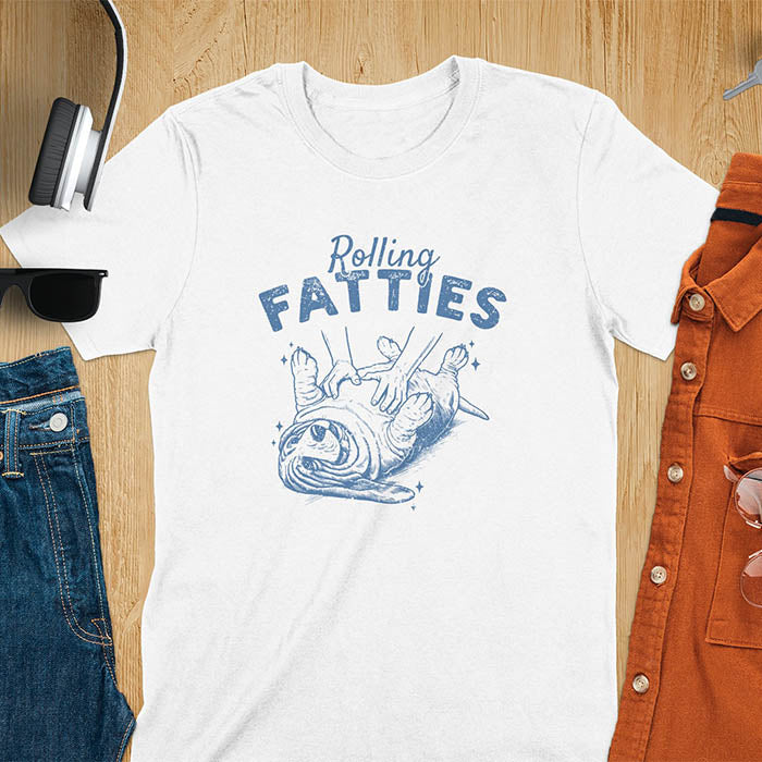 A t-shirt with a basset hound dog on its back getting a belly rub. Text: "Rolling FATTIES". This Rolling Fatties Dog Shirt is a Basset Hound Owner T-shirt, basset hound tee. A Funny Graphic Tee for Dog cuteness gift, Doggy doggie gift, Kawaii Cute Fat Puppy. Perfect gift for dog lover, Dog dad shirt, Dog mama shirt, Dog owner tshirt, pet vintage shirt, Pet lover apparel, Animal Lover Gift, Dog person clothe, Gift mom hers. An Unhinged Tee-shirt, Retro dog shirt, Vintage dog tee.