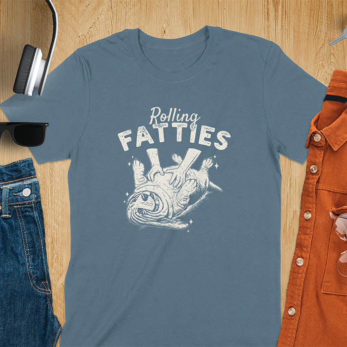 A t-shirt with a basset hound dog on its back getting a belly rub. Text: "Rolling FATTIES". This Rolling Fatties Dog Shirt is a Basset Hound Owner T-shirt, basset hound tee. A Funny Graphic Tee for Dog cuteness gift, Doggy doggie gift, Kawaii Cute Fat Puppy. Perfect gift for dog lover, Dog dad shirt, Dog mama shirt, Dog owner tshirt, pet vintage shirt, Pet lover apparel, Animal Lover Gift, Dog person clothe, Gift mom hers. An Unhinged Tee-shirt, Retro dog shirt, Vintage dog tee.
