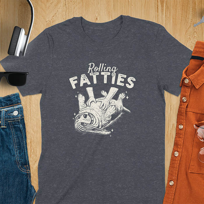 A t-shirt with a basset hound dog on its back getting a belly rub. Text: "Rolling FATTIES". This Rolling Fatties Dog Shirt is a Basset Hound Owner T-shirt, basset hound tee. A Funny Graphic Tee for Dog cuteness gift, Doggy doggie gift, Kawaii Cute Fat Puppy. Perfect gift for dog lover, Dog dad shirt, Dog mama shirt, Dog owner tshirt, pet vintage shirt, Pet lover apparel, Animal Lover Gift, Dog person clothe, Gift mom hers. An Unhinged Tee-shirt, Retro dog shirt, Vintage dog tee.