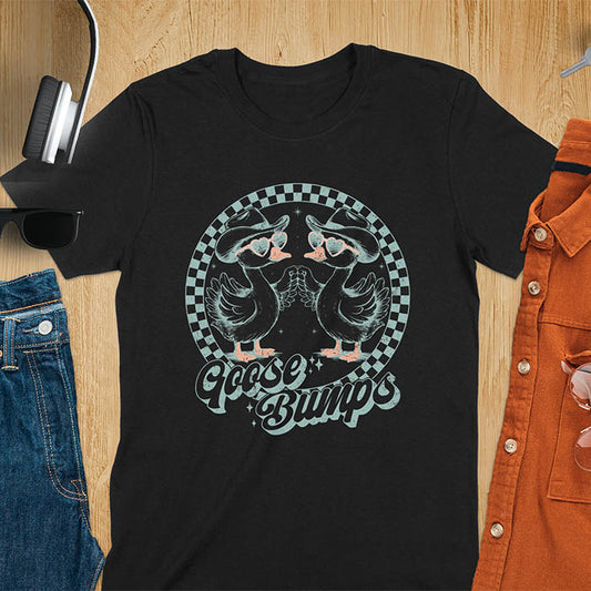 A t-shirt with two geese in cowboy hats and heart sunglasses touching hands, inside a checkered circle. Text "Goose Bumps" is below them on a curved banner. A silly goose crewneck, sarcastic, Funny Sarcastic Meme Tee-shirt, Retro Western Goose Shirt, Snarky Sassy Saying Tshirt, unhinged tee-shirt, weirdcore meme. Ideal gift for goose lover, cowboy cowgirl gift, animal person, gift mom hers. Features kawaiiness cuteness, cute animal clothe, Vintage Silly Humorous Tee Gift.