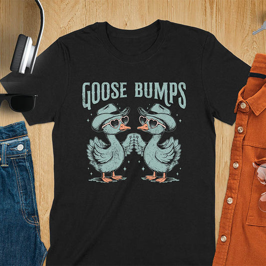 A t-shirt with two geese in cowboy hats and heart sunglasses touching wings. The phrase "GOOSE BUMPS" is positioned above them. This Goose Bumps T-shirt is a silly goose crewneck, funny goose shirt, Retro Vintage Humorous Tee Gift. A Western Sarcastic Silly Meme Shirt, Snarky Sassy Saying Tee-shirt, unhinged tee-shirt, funny sarcasm gift, funny outfit. Ideal gift for goose lover, animal person, Animal Lover Tshirt, gift mom hers. Features kawaiiness cuteness, cute animal clothe, cowboy aesthetic.