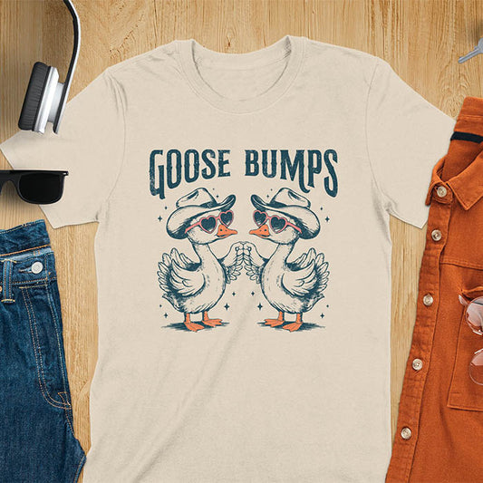 A t-shirt with two geese in cowboy hats and heart sunglasses touching wings. The phrase "GOOSE BUMPS" is positioned above them. This Goose Bumps T-shirt is a silly goose crewneck, funny goose shirt, Retro Vintage Humorous Tee Gift. A Western Sarcastic Silly Meme Shirt, Snarky Sassy Saying Tee-shirt, unhinged tee-shirt, funny sarcasm gift, funny outfit. Ideal gift for goose lover, animal person, Animal Lover Tshirt, gift mom hers. Features kawaiiness cuteness, cute animal clothe, cowboy aesthetic.