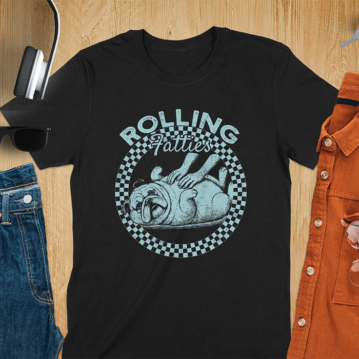 Black colored unisex t-shirt featuring 'Rolling Fatties' text in blue lettering above a cute chubby bulldog lying on its back within a blue and white checkered circle border