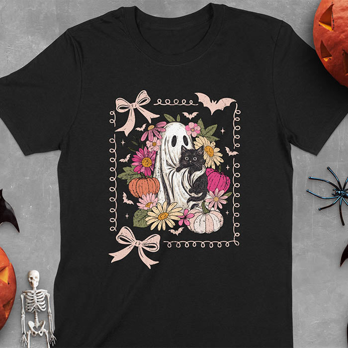 Black t-shirt featuring cute ghost holding black cat surrounded by pumpkins, bats, and floral elements in cottagecore coquette style