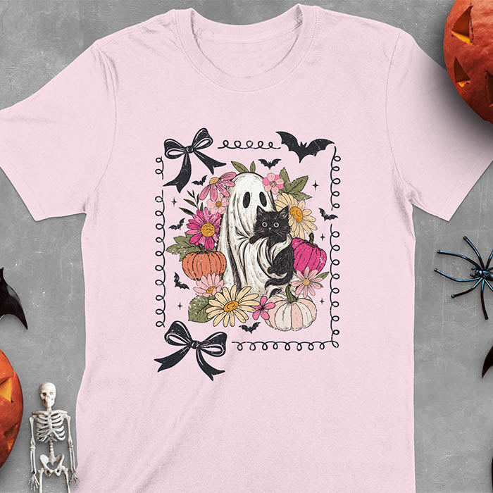Light Pink t-shirt featuring cute ghost holding black cat surrounded by pumpkins, bats, and floral elements in cottagecore coquette style
