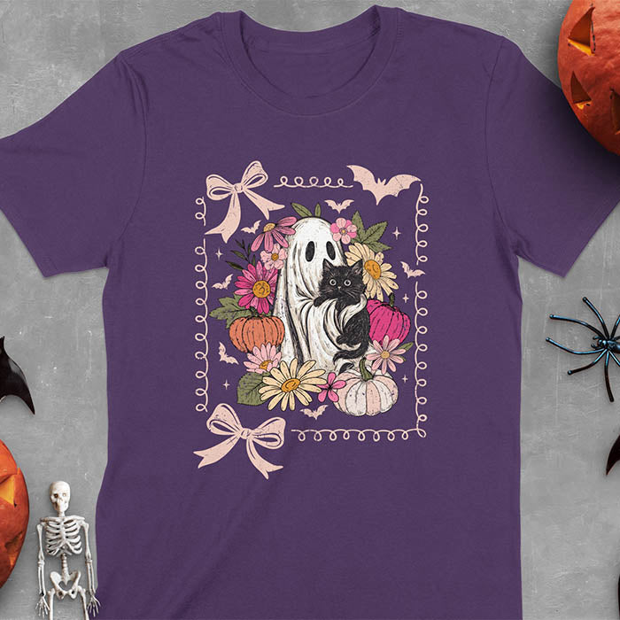 Purple t-shirt featuring cute ghost holding black cat surrounded by pumpkins, bats, and floral elements in cottagecore coquette style