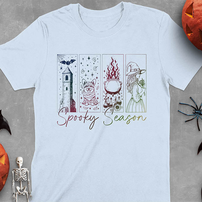Light blue t-shirt featuring four ombre color panels with haunted house, mummy corgi, bubbling cauldron, and witch figure, with 'Spooky Season' text below
