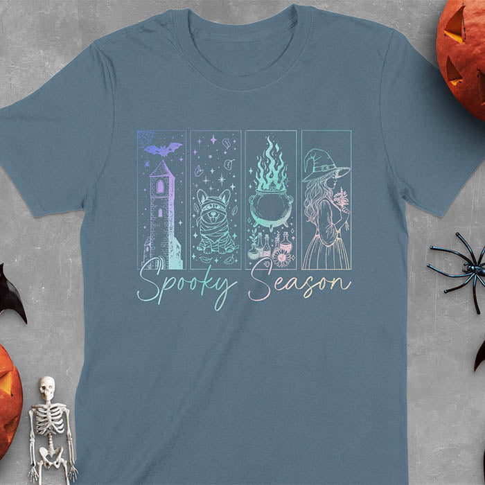 Indigo Blue t-shirt featuring four neon panels with haunted house, mummy corgi, bubbling cauldron, and witch figure, with 'Spooky Season' text below