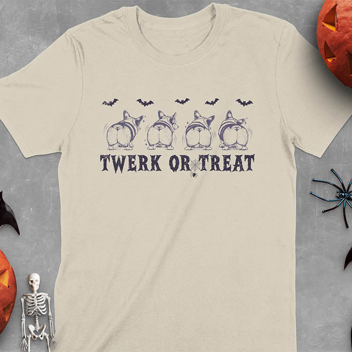 Sand colored t-shirt with "Funny Halloween Corgi Twerk or Treat T-Shirt - Four Corgis showing their butts in Halloween theme