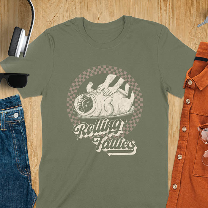 Military Green t-shirt with 'Rolling Fatties' text and illustration of chubby pug lying on its back inside black and white checkered circle border, with human hands reaching toward pug's belly