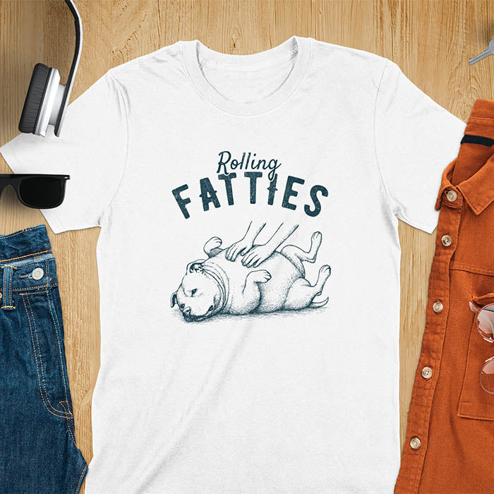 White t-shirt with 'Rolling Fatties' text and illustration of chubby pitbull dog lying on its back with paws up, with human hands on the dog's belly