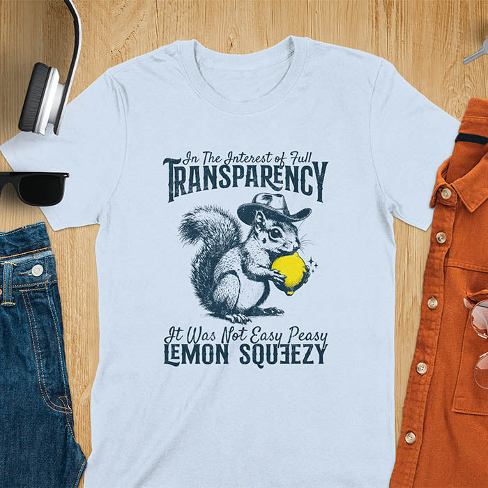 Light blue t-shirt featuring illustrated squirrel wearing cowboy hat and holding yellow lemon with text 'In The Interest of Full Transparency It Was Not Easy Peasy Lemon Squeezy' - funny sarcastic meme design
