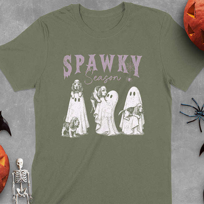 Military Green Halloween T-shirt featuring 'SPAWKY Season' text with cute white ghosts carrying Basset Hound puppies, designed in purple ink with playful Halloween theme