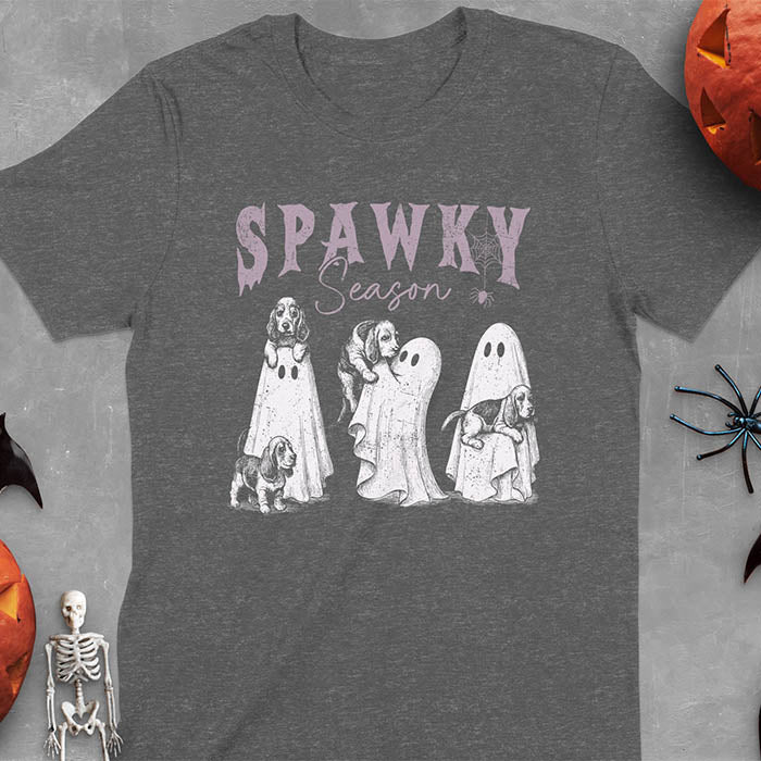 Dark heather Halloween T-shirt featuring 'SPAWKY Season' text with cute white ghosts carrying Basset Hound puppies, designed in purple ink with playful Halloween theme