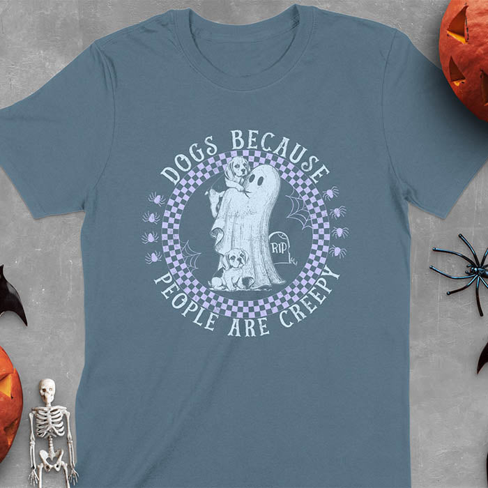 Indigo Blue Halloween t-shirt featuring a cute ghost holding a beagle puppy with another beagle sitting on the ground next to a tombstone marked 'RIP', surrounded by spiders in a circular checkered border design with text 'DOGS BECAUSE PEOPLE ARE CREEPY'