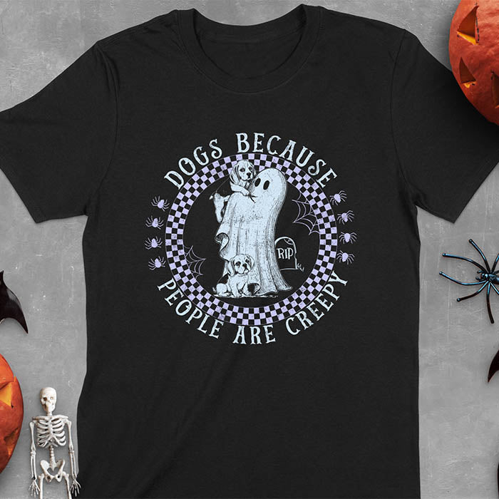 Black Halloween t-shirt featuring a cute ghost holding a beagle puppy with another beagle sitting on the ground next to a tombstone marked 'RIP', surrounded by spiders in a circular checkered border design with text 'DOGS BECAUSE PEOPLE ARE CREEPY'
