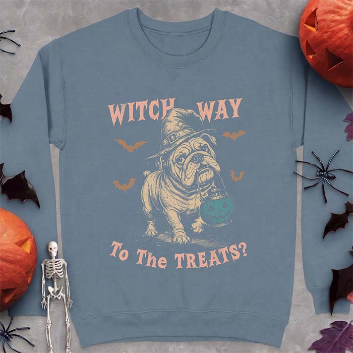Indigo Blue sweatshirt with a Halloween graphic of an English Bulldog wearing a patched witch hat carrying a glowing jack-o'-lantern lantern in its mouth with bats flying nearby and the text Witch Way To The Treats?