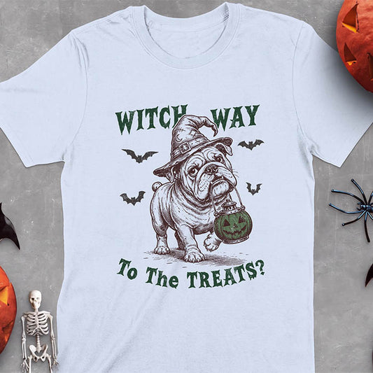 Light Blue t-shirt with a Halloween graphic of an English Bulldog wearing a patched witch hat carrying a glowing jack-o'-lantern lantern in its mouth with bats flying nearby and the text Witch Way To The Treats?
