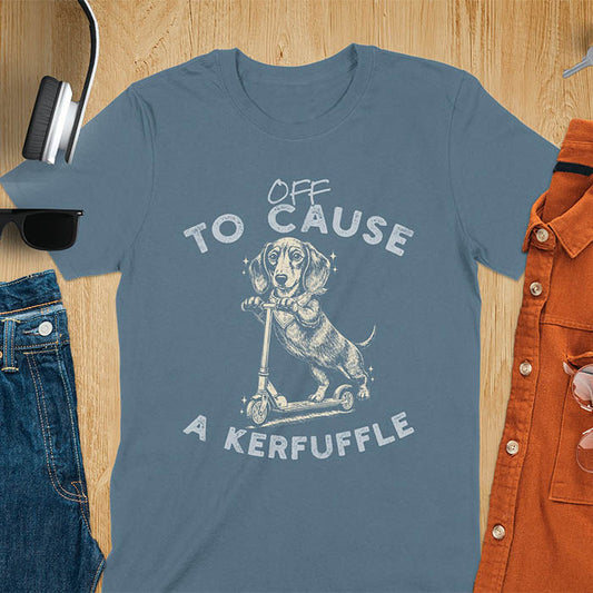 Dachshund on kick scooter illustrated graphic with Off To Cause A Kerfuffle text on indigo blue t-shirt