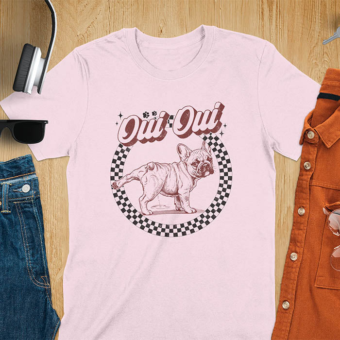French Bulldog Oui Oui pun t-shirt with checkered circle border and retro script lettering on light pink tee