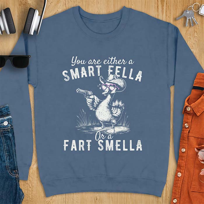 Indigo Blue sweatshirt with a cowboy goose illustration wearing a hat and pink heart shaped sunglasses, holding a revolver, and the text You Are Either A Smart Fella Or A Fart Smella