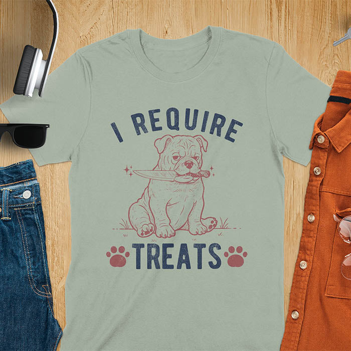 Sage green tee with "I Require Treats" text and grumpy bulldog puppy holding knife in mouth and paw prints vintage graphic
