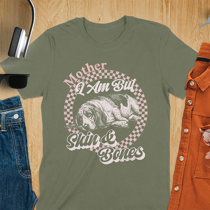 Military green t-shirt with a vintage graphic of a basset hound lying down inside a retro checkered circle, with the text Mother I Am But Skin and Bones