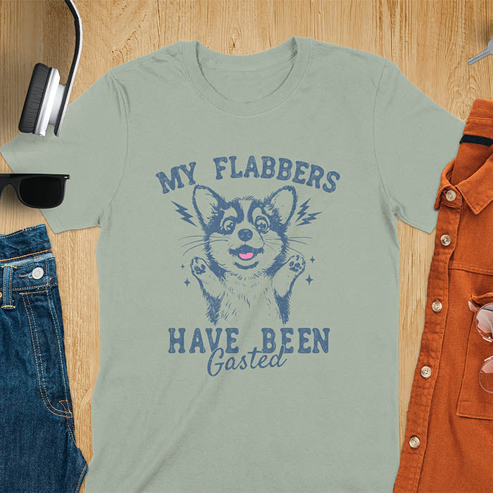 A sage t-shirt with a bewildered corgi with its paws up. Text: MY FLABBERS above and HAVE BEEN GASTED below. This sarcastic tee-shirt features kawaiiness cuteness, a genz meme tee. A depress meme and anxiety tshirt, a funny gag gift. One of those shirts that go hard, a weirdcore memes and sad core aesthetic. A mom gift alternative.