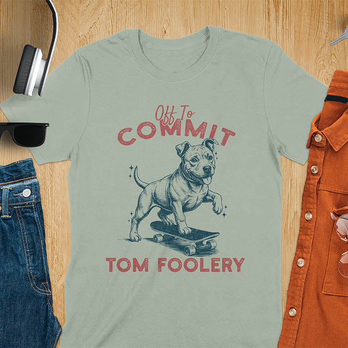 Sage green t-shirt featuring a pitbull riding a skateboard with text Off To Commit Tom Foolery in vintage red lettering