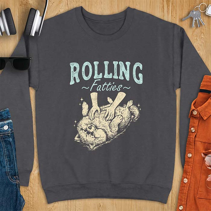 Dark Heather sweatshirt with a graphic of a fluffy Pomeranian rolled onto its back getting a belly rub from two hands and the text Rolling Fatties