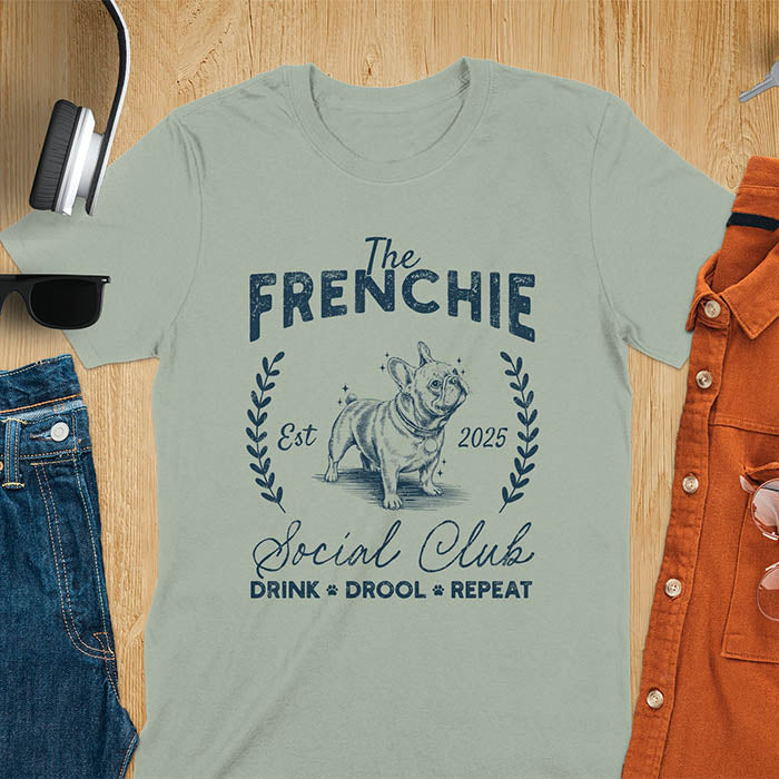 Sage green t-shirt with vintage French Bulldog graphic design featuring 'The FRENCHIE Social Club' text and Frenchie illustration.