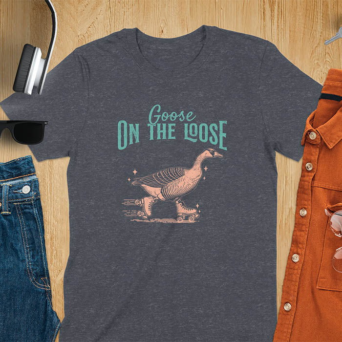 "Goose on the Loose" shirt features a goose on roller skates in motion, with vintage distressed font and colors. Perfect for fans of funny goose shirts, meme tees, sarcastic shirts, silly goose vibes, Y2K clothing, and animal lover gifts.